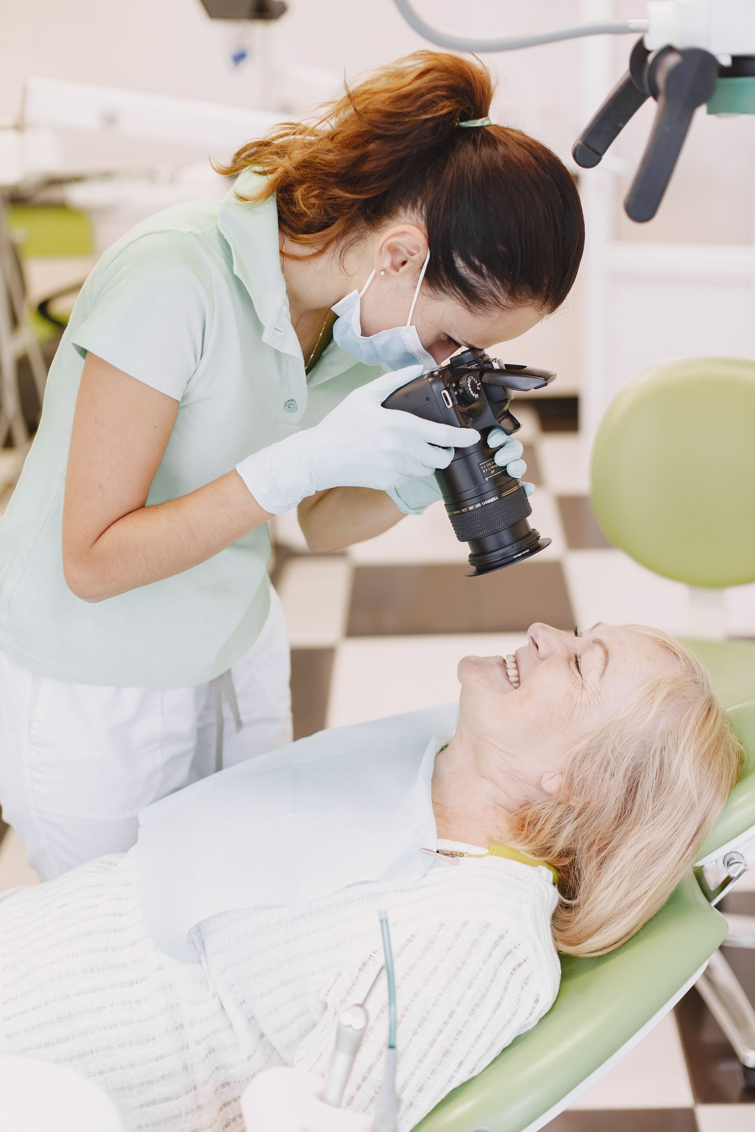 A dental clinician photographs a patient's mouth for the clinical record.